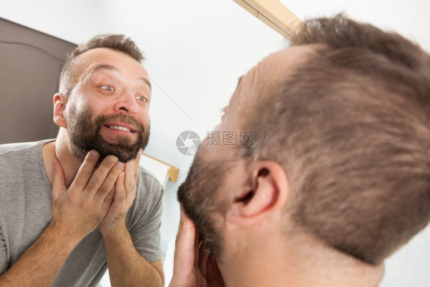 成年熟男子在调查他未刮坏的面部头发图片