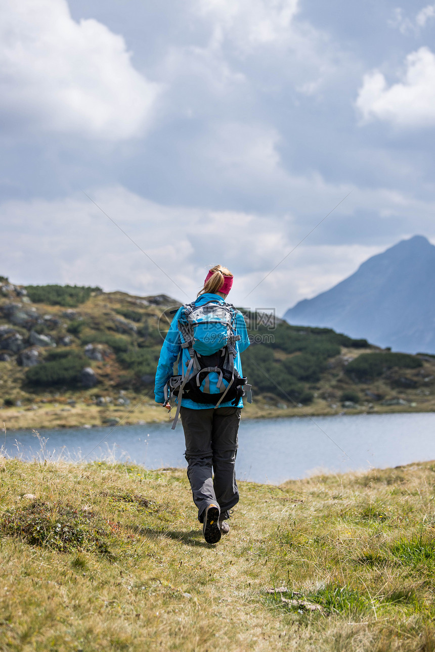 职业运动穿服的妇女正在山上徒步旅行奥地利图片