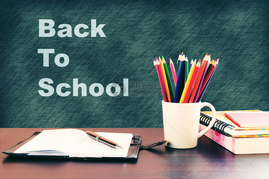 回到学校概念书本和彩色铅笔放在木制桌上写黑板图片