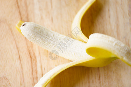 香蕉皮接近新鲜成熟香蕉果木板上的香蕉果背景图片