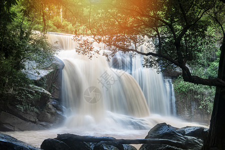 美丽的瀑布景观山上河流中阳光照耀山上有树和岩石地表瀑布塔伊兰热带森林图片