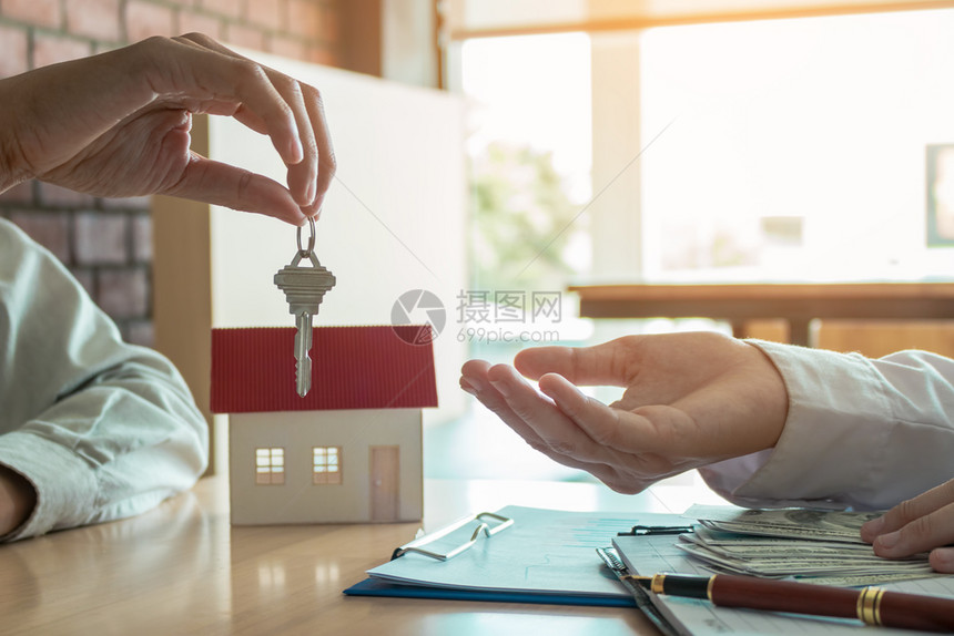 销售商家庭经纪人为新房主提供钥匙图片