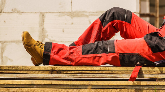 建筑工地上无法辨认的人身着保护工的红色黑裤子身着保护工人的红色黑裤子图片