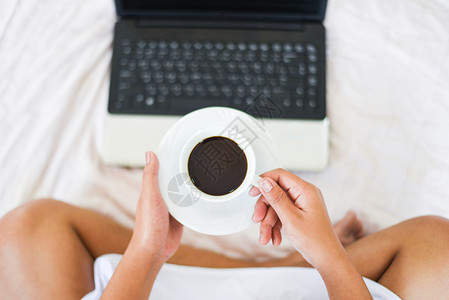 早上咖啡杯顶部风景妇女用笔记本电脑手持咖啡杯图片