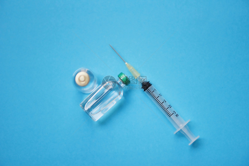 蓝底药瓶玻璃和注射针管头药瓶设备护士或医生疗工具图片