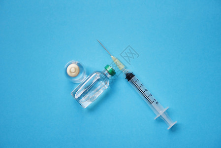 蓝底药瓶玻璃和注射针管头药瓶设备护士或医生疗工具背景图片