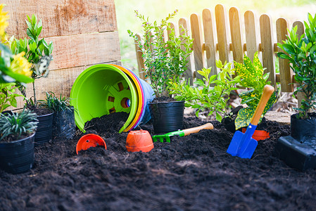 园艺工具土壤背景上丰富多彩的锅罐准备种植花和小物在后院的园艺工程概念背景图片
