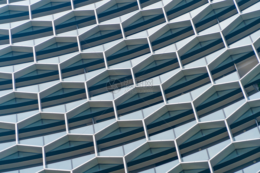 办公室建筑未来技术网络连接概念中六边形窗口的结构蓝玻璃现代建筑设计外观反映市区中心的天空图片