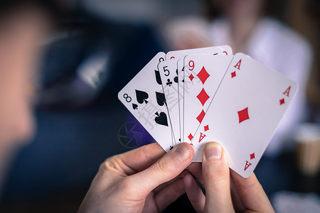 扑克游戏素材在家里玩牌朋友坐在桌子上男人打牌背景模糊背景