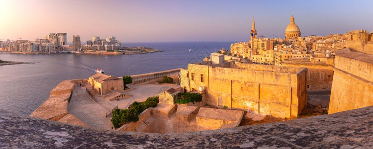 Sliema和老城瓦莱塔与我们圣母卡梅尔山教堂和圣保罗尔斯柯教堂圣公会亲天主教徒在马耳他首都市瓦莱塔日落背景图片