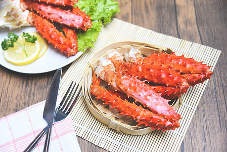 阿拉斯加螃蟹阿拉斯加国王螃蟹腿在木制桌子红蟹北海道用白板上的柠檬香料煮海鲜背景