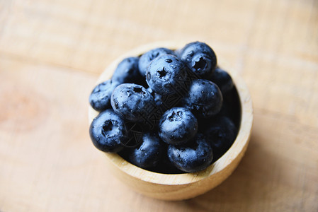 木桌背景上的蓝莓水果碗图片