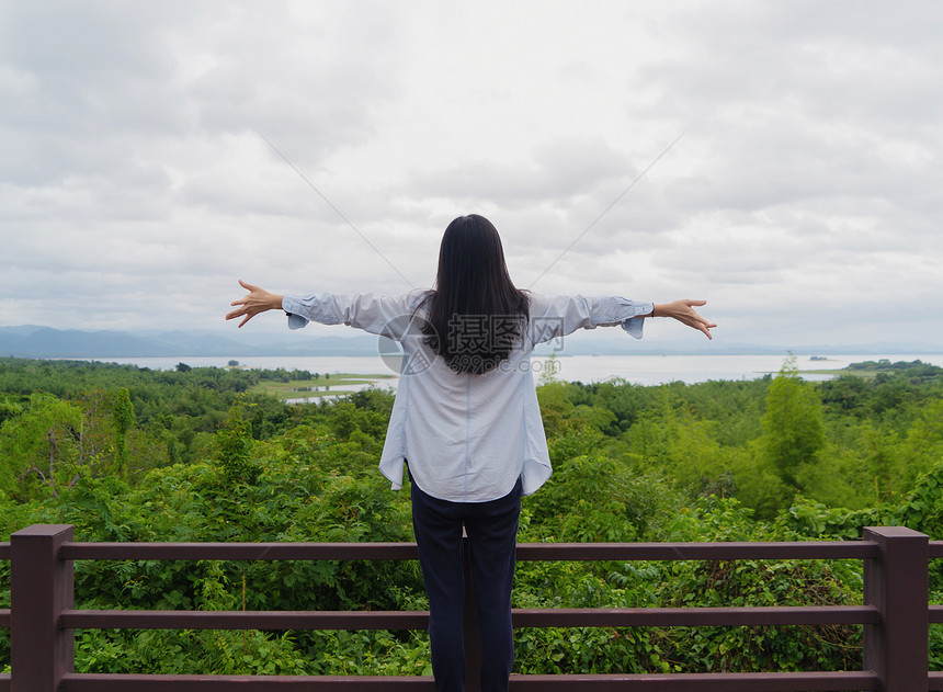 快乐的亚洲妇女在泰国坎沙纳布里家公园旅行和户外度假时在热带森林中放松和享受树木图片