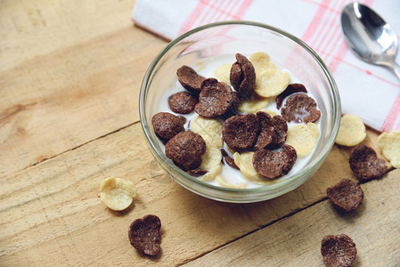 早上餐健康食品木桌边碗牛奶杯中的谷物和玉米片作为早餐健康食品图片