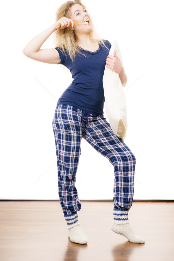 穿着蓝睡衣的快乐妇女拿着枕头和牙刷睡衣穿蓝色T恤衫和检查裤子的快乐妇女穿着睡衣的快乐妇女图片