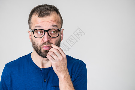 成人聪明穿着眼镜和蓝衬衫有思想专注的面部表情男人专注于他的工作思考想图片