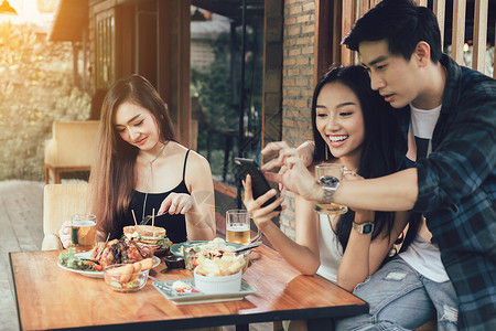 单身女人与餐厅吃饭拍照的情侣背景图片