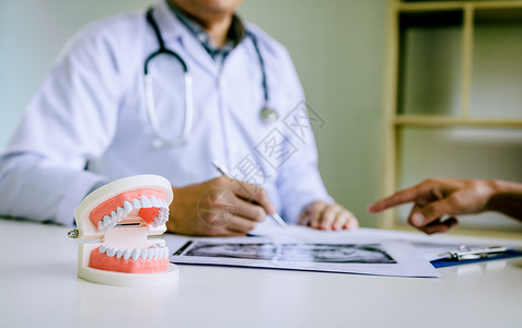 牙医们在报告病人X光照片中讨论牙科问题图片