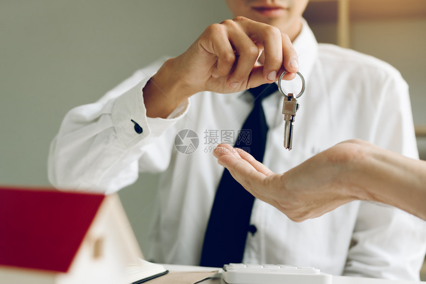 贴近手头的房地产经纪人将钥匙传给新房主图片