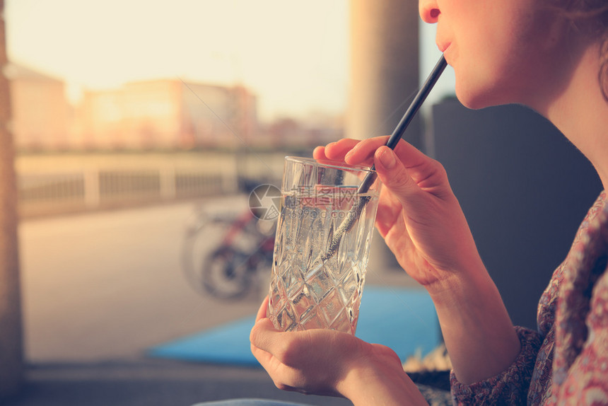 女人拿着一杯子饮料和冰块图片