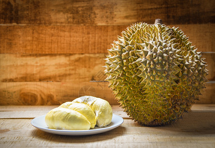 佩德夏天Durian在木制背景上撕碎了盘子和土豆果夏天Durian在木制背景上撕扯了土豆果背景