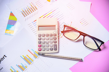 带有计算笔和粉红背景眼镜的计算器笔和墨镜的商务图表报告纸财务文件图片