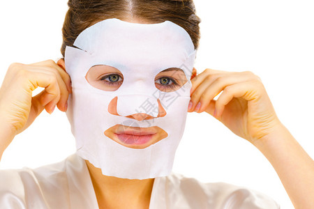 妇女用面罩蒙在脸上白的照顾皮肤美容处理皮肤用面罩蒙在脸上的用面罩遮在脸上的背景图片