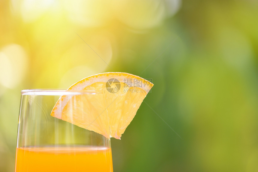 橙汁和子果玻璃上加橙果具有自然质绿色夏季背景选择重点图片