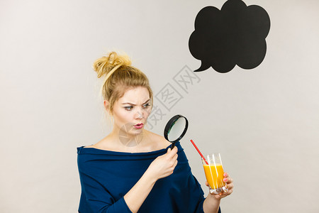 金发女人拿着放大镜调查紧盯着玻璃旁边有橙汁黑思考或言语泡图片