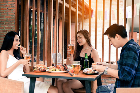 年轻的亚洲人周末在餐厅喝啤酒玩得很开心图片
