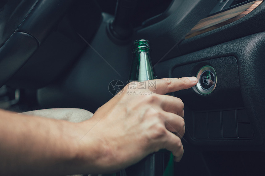 男人手握着啤酒瓶按引擎启动钮图片