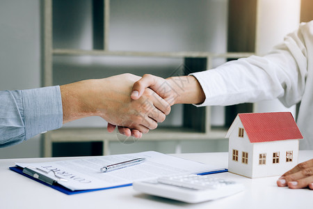 家庭销售代理商和买家努力签署新房和握手背景