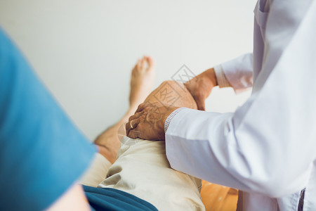 理疗师正在用病人膝盖的手柄检查疼痛情况治愈高清图片素材
