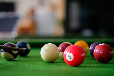 桌上游戏Man手和Cue臂在玩Snooker游戏或准备在绿色球桌上绿色盘上有多彩的Snooker球背景
