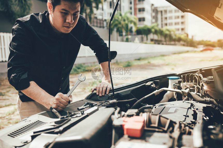 汽车修理工拿着扳手准备检查引擎图片