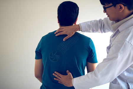 理疗师用手检查病人的背部医生高清图片素材