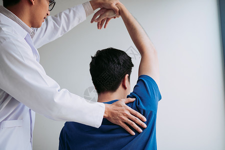 在医务室伸展一名年轻男子手臂脊椎按摩师高清图片素材