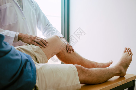 理疗师正在用病人膝盖的手柄检查疼痛情况康复中心高清图片素材