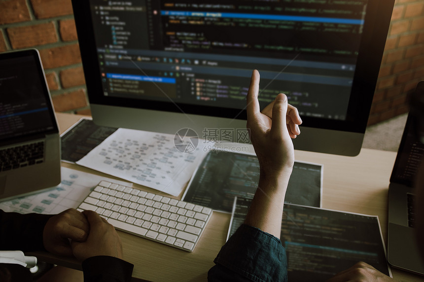 两位软件开发商正在共同分析计算机程序所写入的代码图片