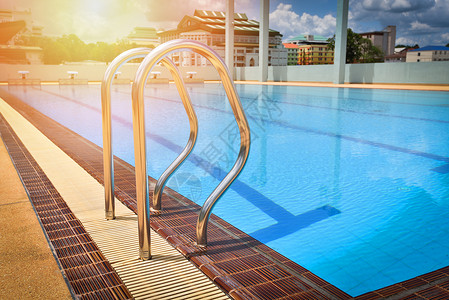 在户外竞争游泳池上用蓝水地表阶梯抓铁条子竞争游泳池图片