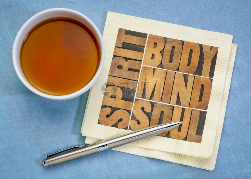 文体心和精神在餐巾纸上用旧木印刷板打的文字并配有茶杯健康生活方式福祉和整体概念图片
