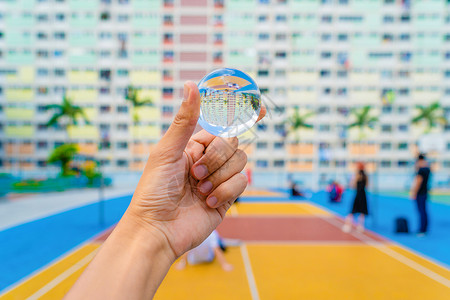 在香港城市公园的彩虹壁画楼里手握着玻璃或水晶球图片