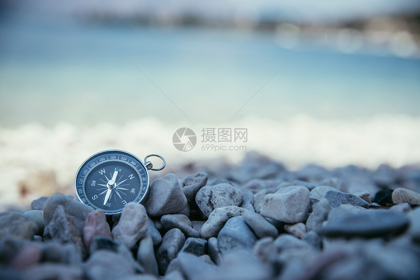 导航近距离接一个罗盘躺在石块海滩上图片