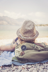 世界旅行前方的指南针女孩躺在海滩上背景模糊图片