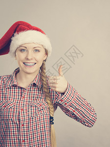 戴风吹圣诞老人帮手帽子的快乐妇女戴圣诞老人帮手帽子的快乐妇女图片