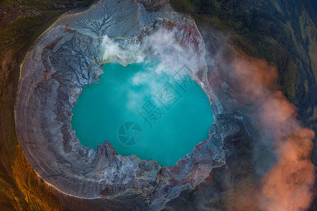 玉虚峰日出时有绿宝石硫磺湖的KawahIjen火山岩悬崖空中景象印度尼西亚东爪哇全景自然观背背景