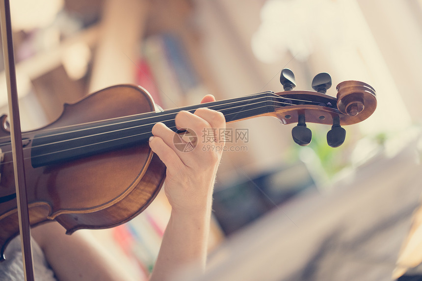 年轻漂亮女孩在小提琴音响乐上练习图片