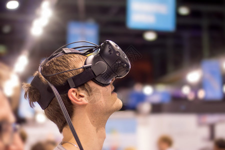 年轻人在博览会上使用虚拟现实眼镜图片