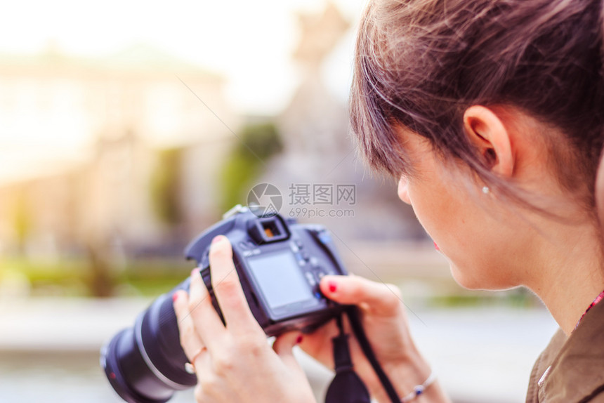 年轻美女正用摄像头拍照从后面看图片