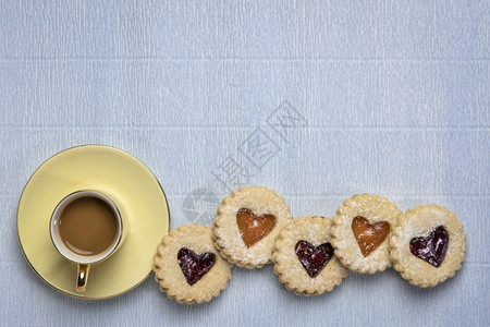 一排果酱饼干杯咖啡在纸质上加一个复制空间咖啡休息甜点或爱的概念图片
